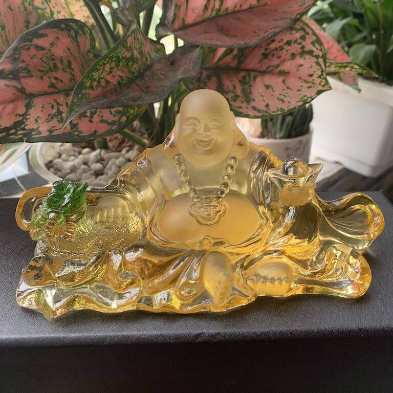Tượng Phật Di Lặc được đặt trên xe ô tô với mong cầu may mắn, an lạc, vui vẻ cho người ngồi trên xe